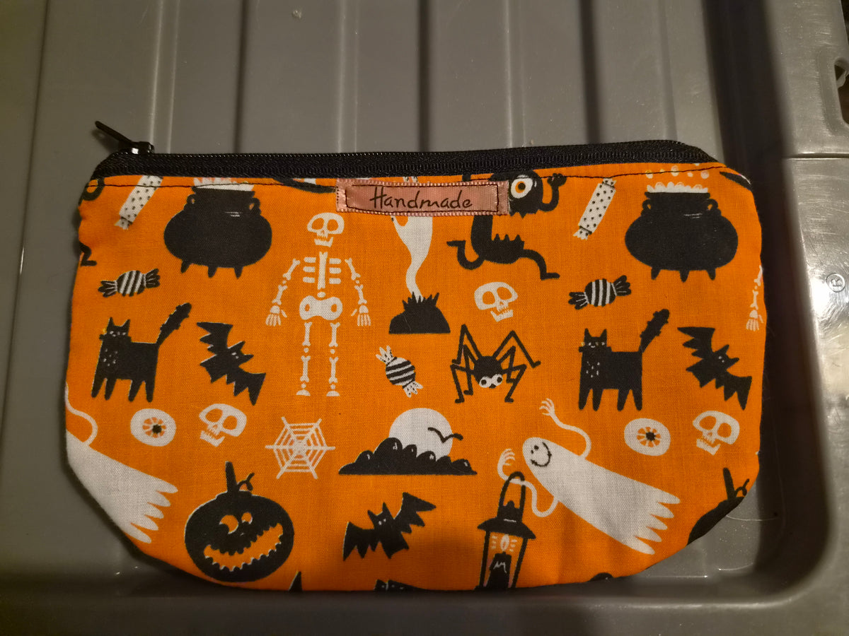 Handmade orange Halloween makeup bag with pumpkins, ghosts, bats, skulls and cats pattern