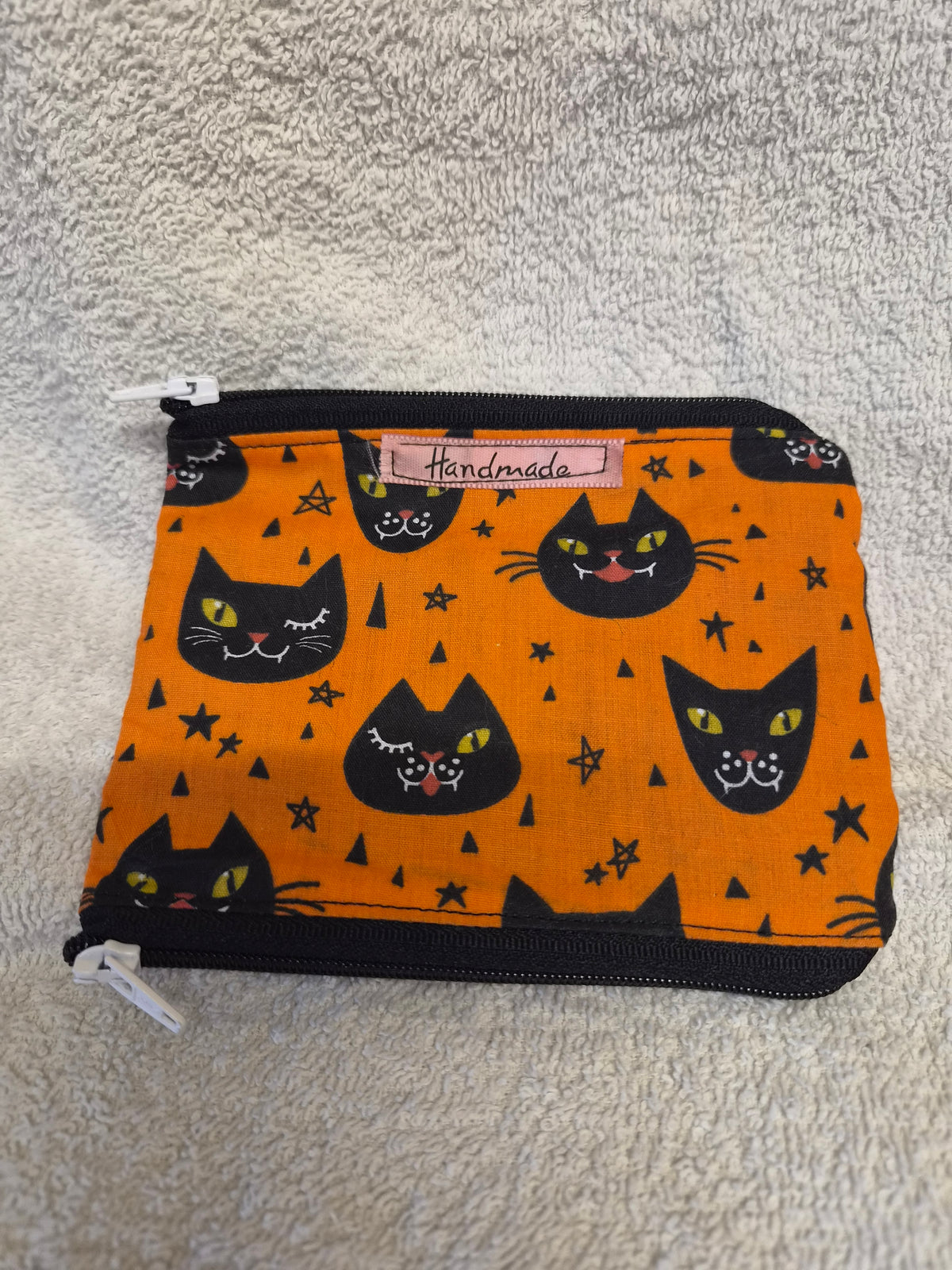 Handmade zip purse with black cat face print on orange fabric