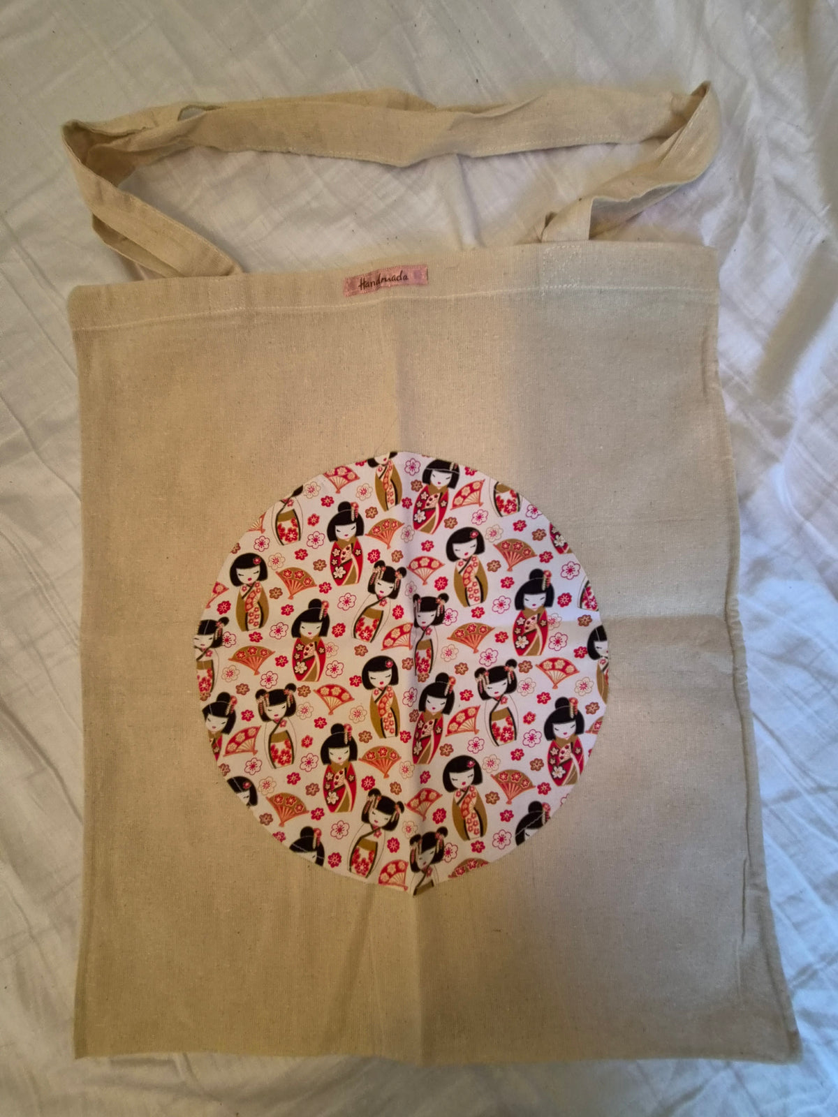 Handmade canvas tote bag with Kokeshi doll circular appliqué